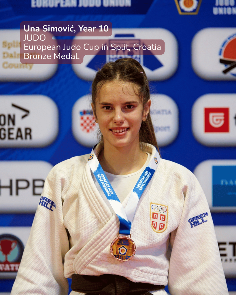 Una Simović Year 10 student wearing a white judogi with a bronze medal at the European Judo Cup in Split Croatia on stage behind sponsor logos